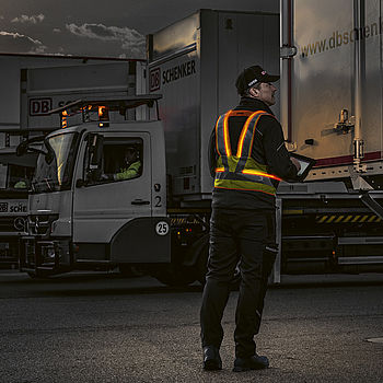[翻译成德语]Bei Dunkelheit im Logistik- and Frachtbereich sorgen aktive Leuchtwesten für Sichtbarkeit