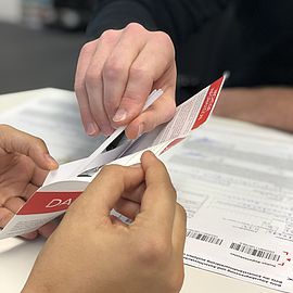 ein-uvex-group-mitarbeiter-verpackt-die-relevanten-formulare-und-die-stäbchen-in-ein-kuvert