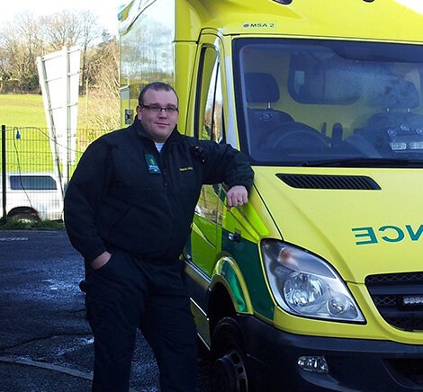 Scot Grant works in both the private medical sector and the NHS Scot Grant stood in front of an ambulance
