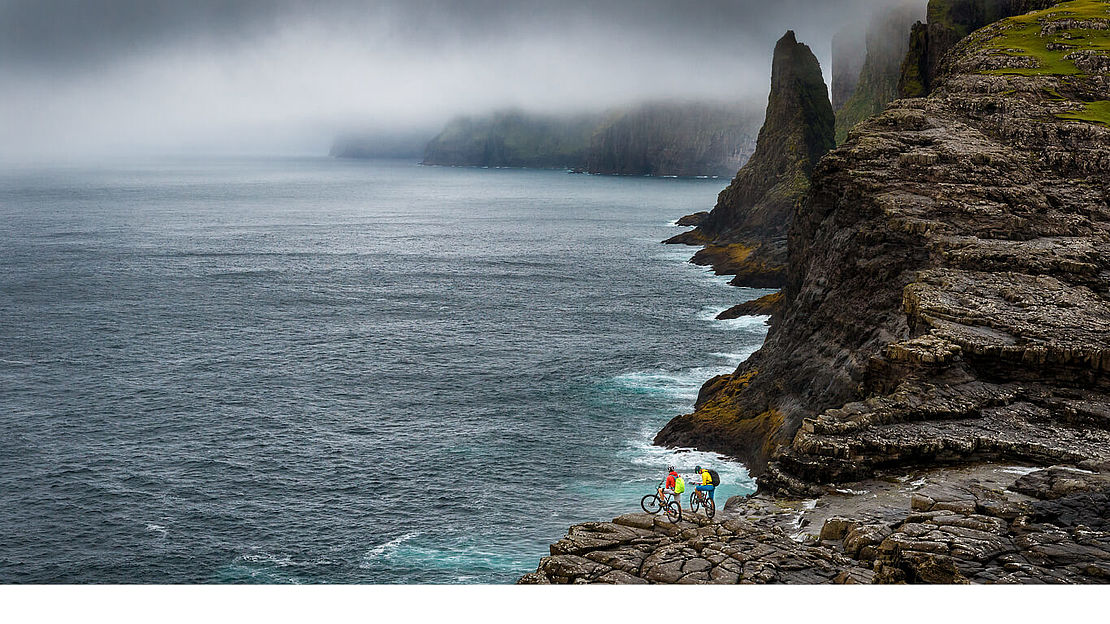Shred on the sheep islands Mountainbiker at the coast of the Faroe Islands