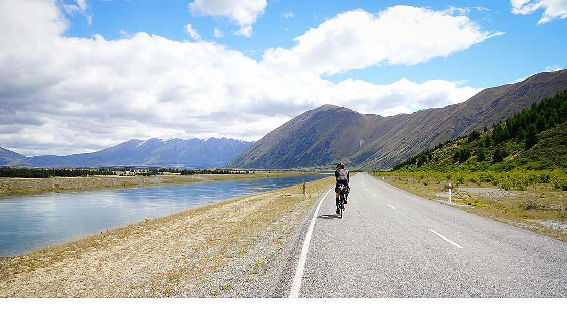 Gravel royal - Cycling through New Zealand Dennis Müller cycling on a road with mountain view