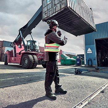 Une personne travaillant en extérieur proche de porte-conteneur équipé de chaussures de sécurité MACCROSSROAD 