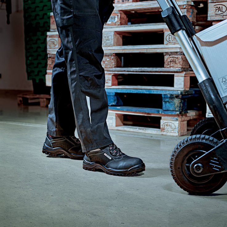 Homme poussant un chariot dans un entrepôt logistique