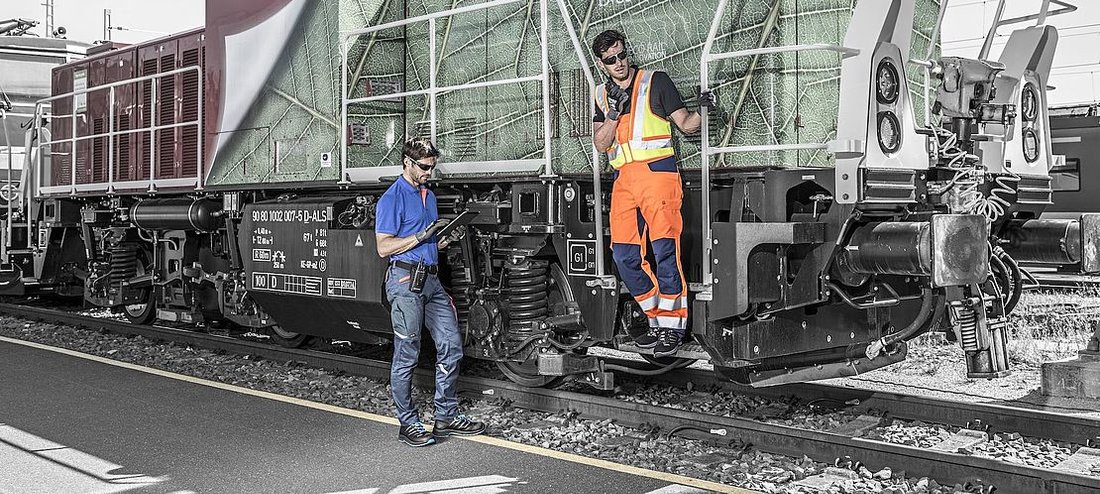 mechanicy w odzieży odblaskowej stoją przy wagonie pociągu