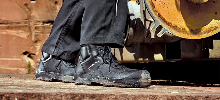 Chaussures de sécurité MACSOLE PLUS en extérieur à côté d'un engin de chantier