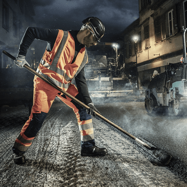 Professionnel lors de travaux d'asphalte portant des chaussures de sécurité Heckel